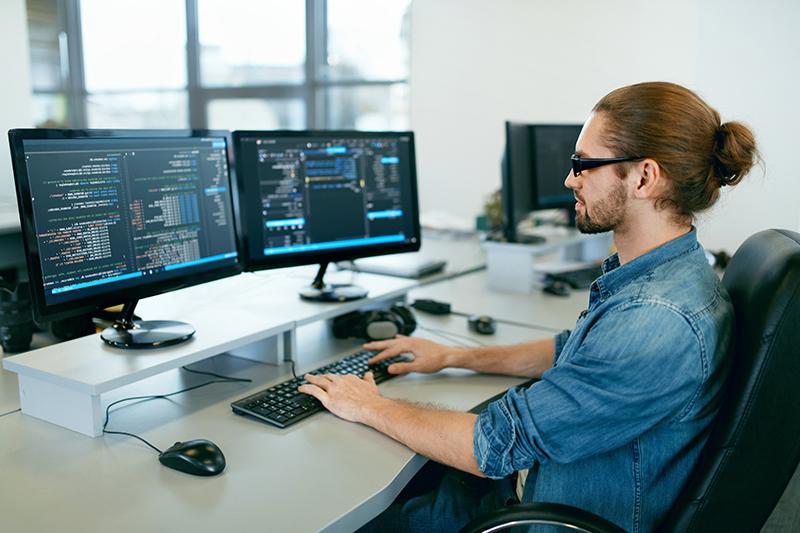 Programming. Man Working On Computer In IT Office, Sitting At Desk Writing Codes. Programmer Typing Data Code, Working On Project In Software Development Company. High Quality Image.